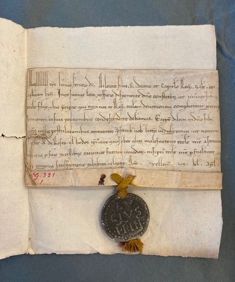 Source : Archives départementales de la Marne (AD 51), Reims, 2G 321/1 (cliché personnel).   Petite bulle du pape datée de 1182/1182 et reconnaissable à son sceau en plomb très bien conservé. 