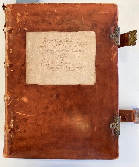 Source : Archives départementales de la Marne (AD 51), Reims, 2G 1650. (Cliché personnel). Codex comprenant 367 folios et appelé par la tradition archivistique locale « Cartulaire A du chapitre » ou encore « livre rouge ». Il est daté du XVe siècle par une note de l’archiviste, mais comporte dans les faits des documents plus anciens, qui sont le signe d’une rédaction beaucoup plus précoce remontant au moins à 1350. C’est un ensemble véritablement composite (copies de chartes, listes de noms, listes de bénéfices des chanoines etc…) et il semblerait qu’il soit le résultat de plusieurs cahiers reliés entre eux